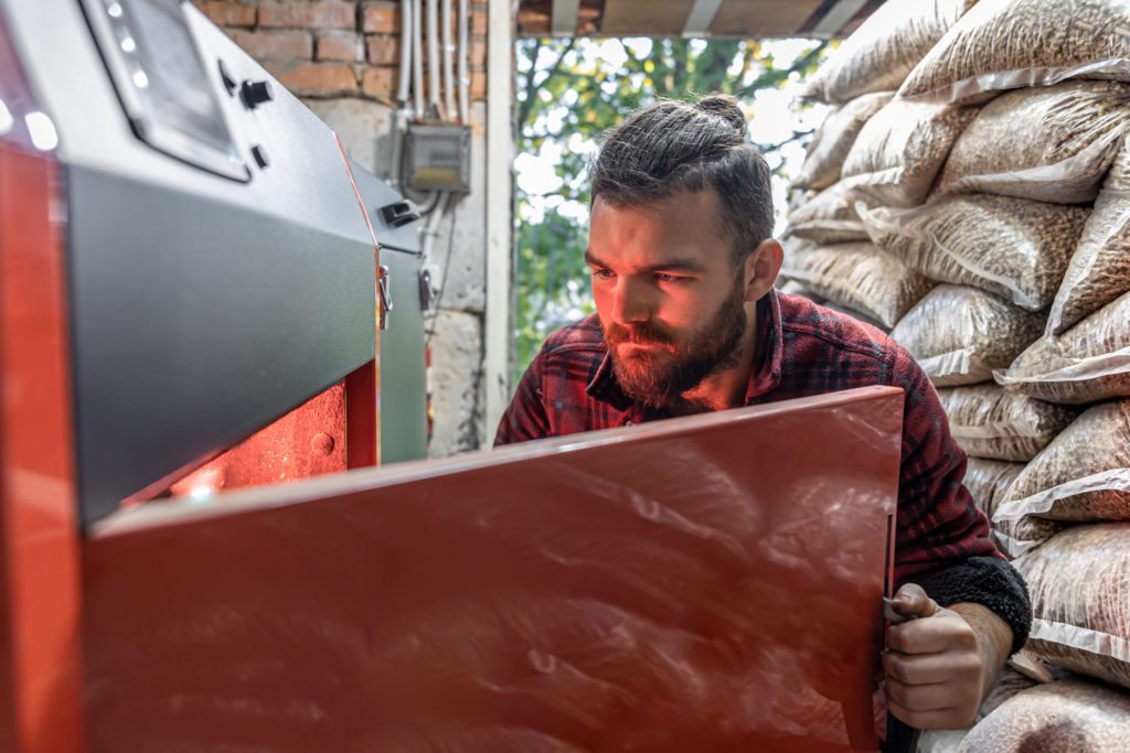 Homme regardant sa chaudière à granulés